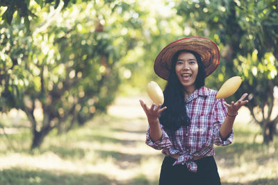 Portrait of farmer playing with mango in farm