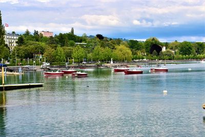 Sailboats moored in lake against sky