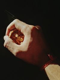 Cropped hand of man holding ganesha sculpture at home