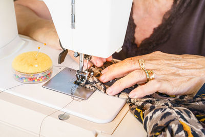 Midsection of woman working on sewing machine