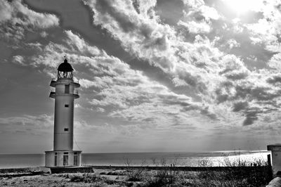 Lighthouse by sea against sky