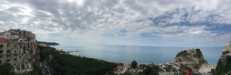 Panoramic view of people on beach against sky