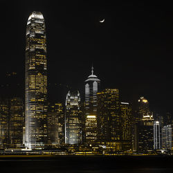 Illuminated buildings against sky at night