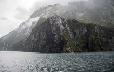 Scenic view of sea and mountains against sky