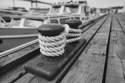 Close-up of rope tied on bollards at harbor