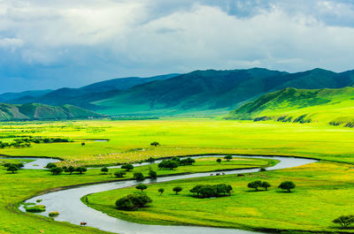 Scenic view of green landscape against sky