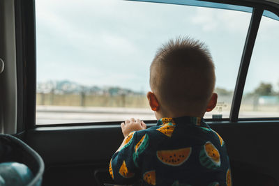 Young boy waiting for airplane landing inside the car