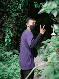 Young man standing by plants