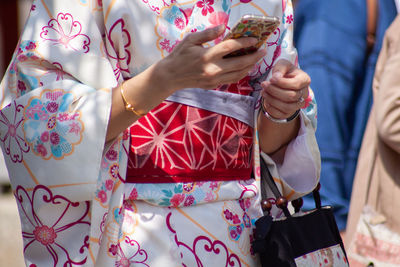 Woman in traditional japanese kimono with a mobile phone in hands
