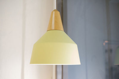 Close-up of pendant light hanging against wall at home