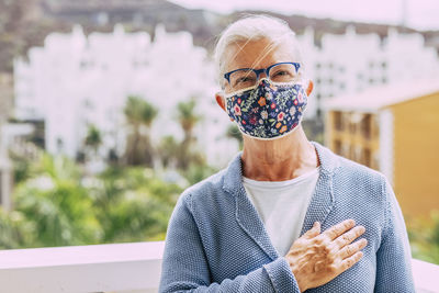 Portrait of woman wearing mask standing outdoors