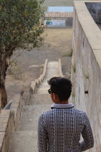 Rear view of man standing on steps