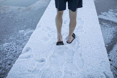 Low section of person standing on snow