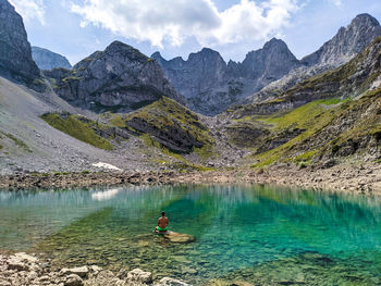 Scenic view of lake by mountains against sky