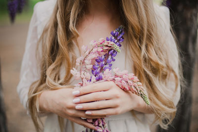 Midsection of woman holding flowers