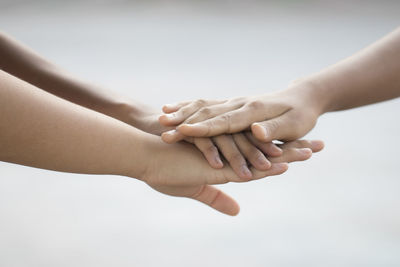 Cropped image of friends stacking hands