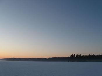 Scenic view of lake against clear sky during sunset