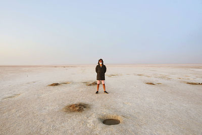 Woman standing on beach against clear sky