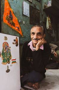 Portrait of young man standing against wall