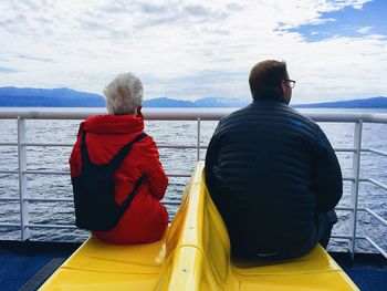 Rear view of men looking at sea against sky