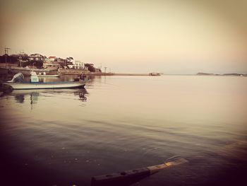 Boats moored at harbor against clear sky