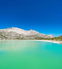 Scenic view of mountains against clear blue sky