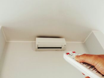 Close-up of human hand on white wall