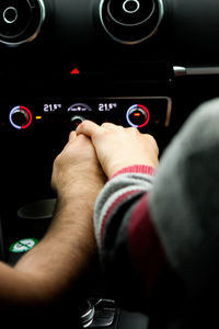 Cropped couple hands in car