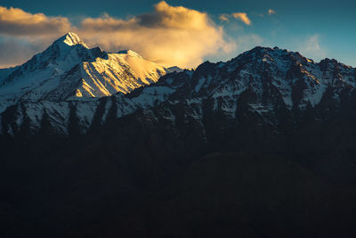 Scenic view of snowcapped mountains against sky during sunset