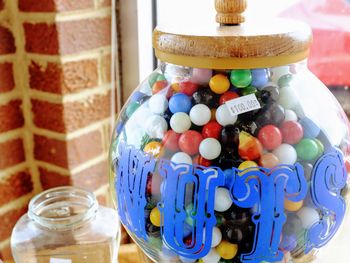 Close-up of multi colored candies in glass jar on table