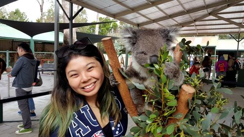 Portrait of smiling woman with animal standing outdoors