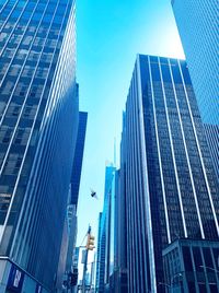 Low angle view of modern buildings against blue sky