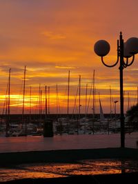 Silhouette sailboats on sea against sky during sunset