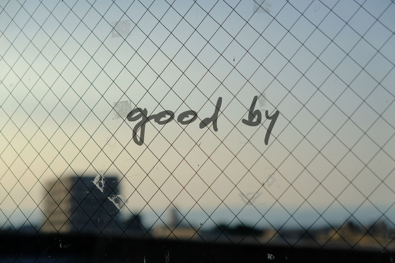 CHAINLINK FENCE AGAINST SKY SEEN THROUGH METAL RAILING