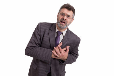 Portrait of businessman with heart attack standing against white background