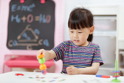 Portrait of cute girl holding table