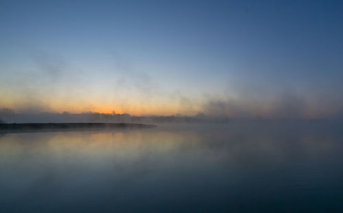 Scenic view of lake against sky during foggy weather