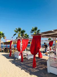 Red flags hanging on beach against clear blue sky