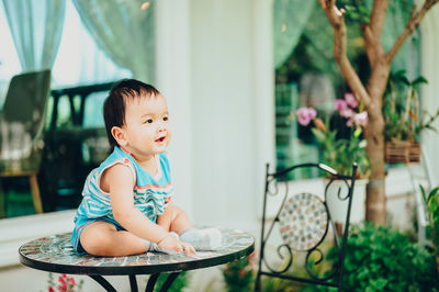 Cute girl looking away while sitting at home