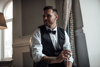 Portrait of young man standing at home