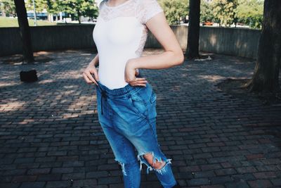 Full length of young woman holding umbrella while standing outdoors