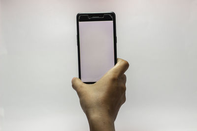 Midsection of man using smart phone against white background