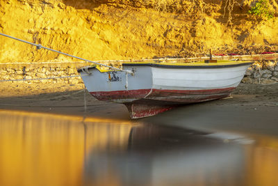 Close-up of fishing boat moored at shore