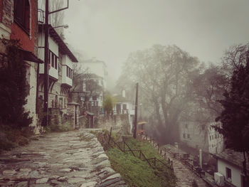 Footpath amidst buildings against sky