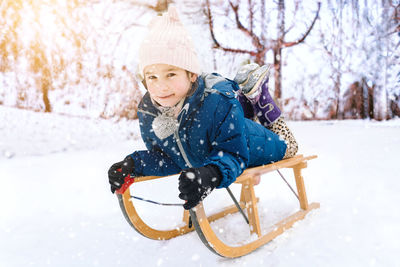 Portrait of smiling young woman standing on snow covered field