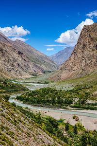 Scenic view of landscape and mountains against blue sky