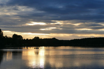 Scenic view of lake against sky at sunset