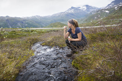 Hiker brushing teeth at stream