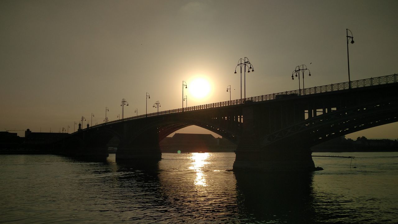 BRIDGE OVER RIVER WITH BUILDINGS IN BACKGROUND