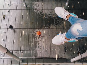 Low section of woman standing above glass floor